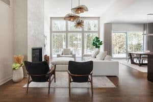 Intérieur lumineux avec grandes fenêtres, mobilier contemporain et décoration naturelle à La Forêt d.